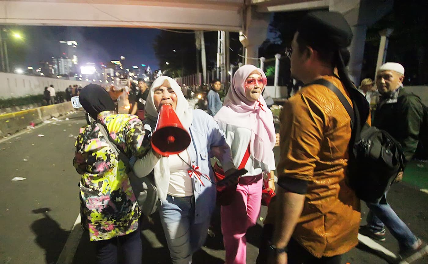 Ratusan massa pendukung hak angket saling dorong dengan aparat Kepolisian di depan gedung DPR, Jakarta, Selasa (19/3/2024) malam. Karena tak kunjung bubar, barikade aparat kepolisian dengan peralatan lengkap helm dan tameng mendorong demonstran agar membu - Image