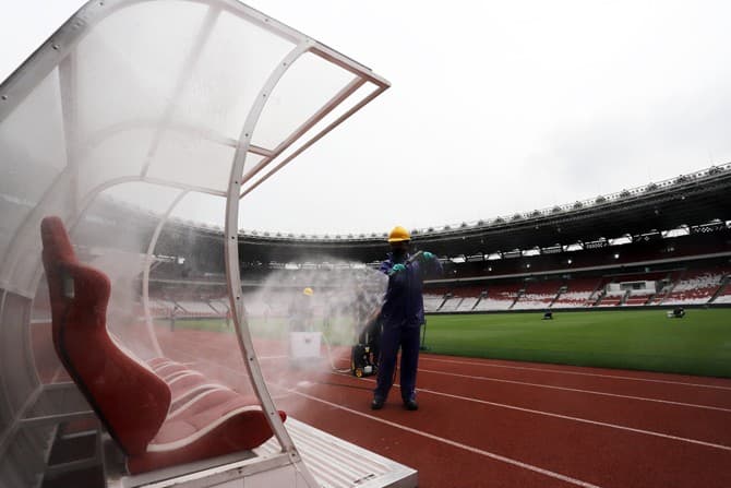 Petugas menyemprotkan cairan disinfektan di Kompleks Stadion Utama Gelora Bung Karno (SUGBK), Senayan, Jakarta, Kamis (26/3/2020). Penyemprotan disinfektan tersebut untuk mencegah penyebaran virus corona (COVID-19) di area tersebut. Foto: Dery Ridwansah/ - Image