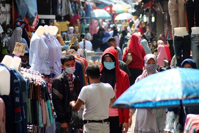 Sejumlah warga melintas di Skybridge Pasar Tanah Abang, Jakarta, Sabtu (26/12/2020). Berdasarkan keterangan pedagang setempat, pandemi COVID-19 mengakibatkan Pasar Tanah Abang sepi pengunjung di hari libur panjang Natal 2020 dan tahun baru 2021. Foto: Der - Image
