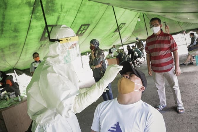 Petugas medis mengambil sampel usap rapid test antigen wisatawan yang akan menuju ke Puncak di halaman Masjid Harakatul Jannah, Gadog, Kabupaten Bogor, Jawa Barat, Jumat, (25/12/2020). Wisatawan yang tidak dapat menunjukkan hasil negatif rapid test antige - Image