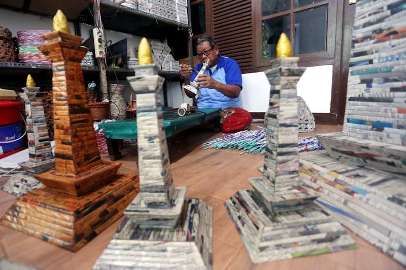 Sugito (86) menyelesaikan pembuatan miniatur Monas dari kertas koran bekas di kawasan Pesanggrahan, Jakarta, Kamis (10/6/2021). Kerajinan yang memanfaatkan limbah kertas koran bekas hasil setoran di bank sampah tersebut dijual dari harga Rp50 ribu hingga - Image