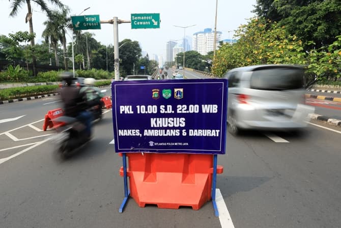 Kendaraan bermotor saat menerobos pembatas cone Penyekatan di kawasan Senayan, Jakarta, Kamis (29/7/2021). Kendaraan tersebut nekat menerobos pembatas penyekatan saat para petugas sedang beristirahat atau saat pergantian petugas jaga saat masa Pemberlakua - Image