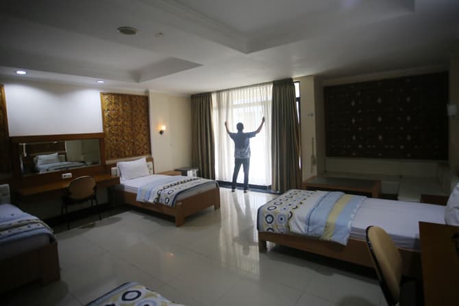 Petugas merapikan kamar untuk jemaah umrah di Asrama Haji, Pondok Gede, Jakarta Timur, Rabu (1/12/2021). Kementerian Agama menyiapkan Asrama Haji Pondok Gede sebagai tempat karantina jemaah umrah dan akan menerapkan kebijakan satu pintu pemberangkatan jem - Image