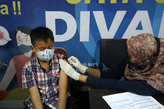 Tenaga Kesehataan menyuntikan vaksin kepada anak-anak di Jakarta, Jumat (18/2/2022). Pemerintah menargetkan 26.705.490 remaja usia 12 hingga 17 tahun menerima vaksin covid-19. Berdasarkan data dari laman vaksin.kemkes.go.id pada Rabu (16/02/2022), Sebanya - Image