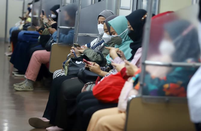 Penumpang duduk tanpa berjarak di dalam KRL Commuter Line, Jakarta, Kamis (10/3/2022). Pemerintah menerbitkan aturan baru naik KRL yaitu tempat duduk tanpa jarak, peningkatan kapasitas hingga 60 persen, balita dibolehkan naik dengan didampingi orang tua, - Image