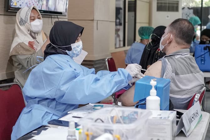 Tenaga medis menyuntikan vaksin booster ke peserta di Masjid Al Itihad Tebet, Jakarta, Sabtu (26/03/2022). Pemerintah mengizinkan kegiatan mudik Lebaran 2022 mendatang. Namun, pelonggaran mudik Lebaran hanya boleh dilakukan oleh masyarakat yang sudah mene - Image