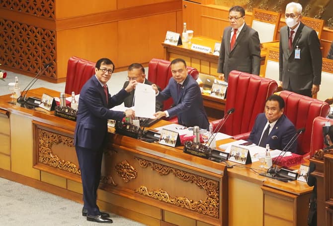 Menteri Hukum dan HAM Yadonna Laoly menyerahkan pandangan pemerintah terait RKUHP kepada Wakil Ketua DPR, Sufmi Dasco didampingi Wakil Ketua DPR, Lodewijk Freidrich Paulus saat Rapat Paripuran DPR di Gedung Nusantara, Kompleks Parlemen, Senayan, Jakarta, - Image